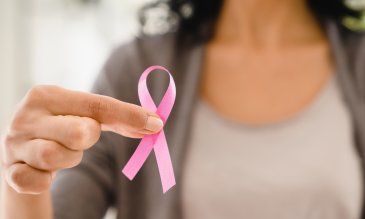woman holding in-focus breast cancer awareness pink ribbon